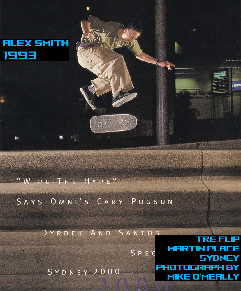Photgraph of Alex Smith doing a Tre Flip over big set of stairs at night under the Sydney City Lights. 
              Each step is bigger than a normal step - at approximately over 30 centimeters high. There a four big steps. Alex is wearing baggy cut-off beige Jeans and Airwalk shoes. 